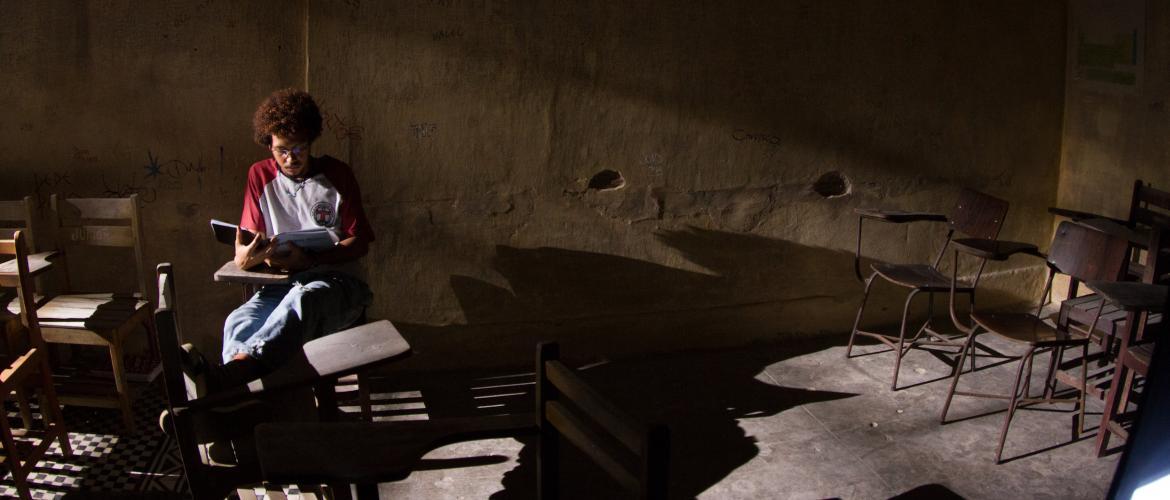 joven sentado en salón de clase 