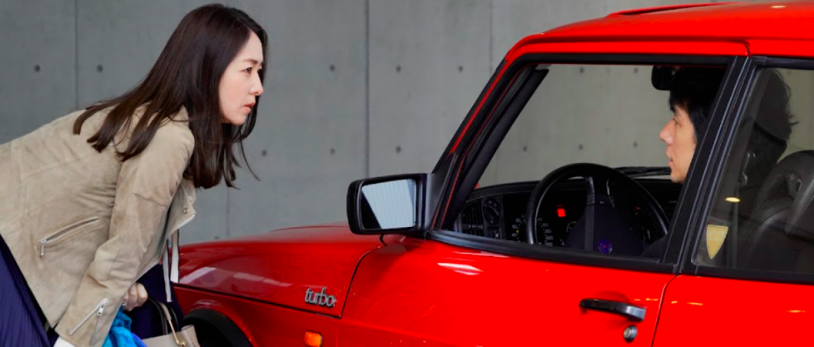 Mujer hablando con un señor que esta en un carro rojo 