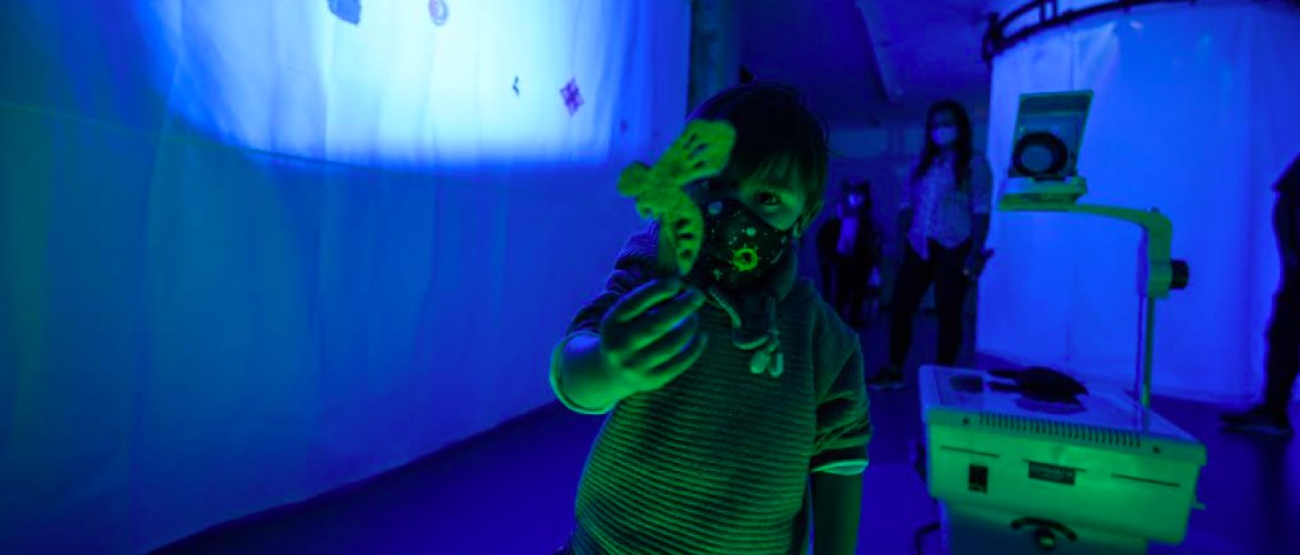 Niño jugando con sombras en un cuarto oscuro 