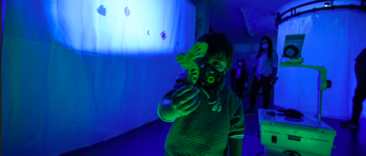 Niño en un cuarto oscuro con un juguete en la mano