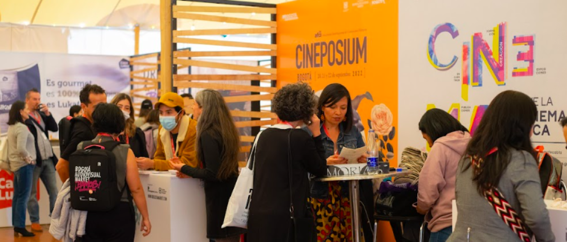 Personas visitando un stand en feria