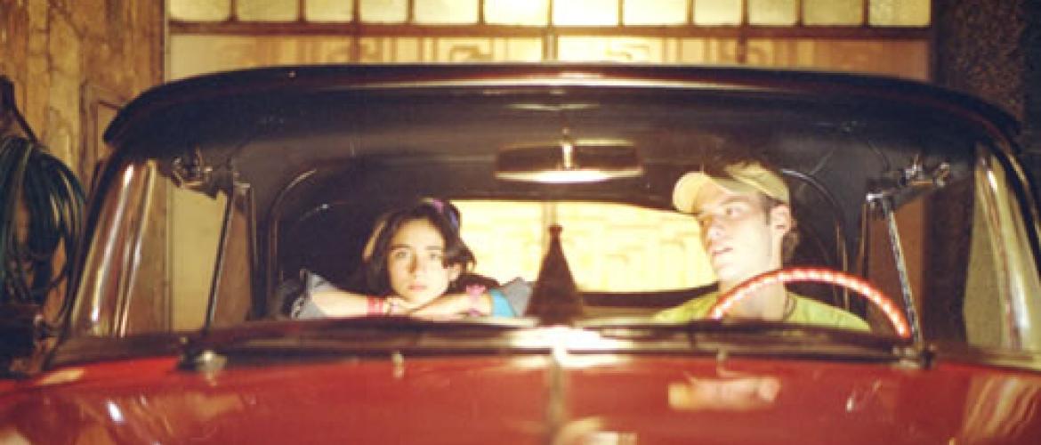 Dos jóvenes en un carro rojo 