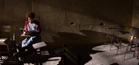 joven sentado en salón de clase 