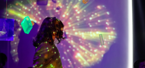 Niño jugando con sombras en un cuarto oscuro con destellos de luz 