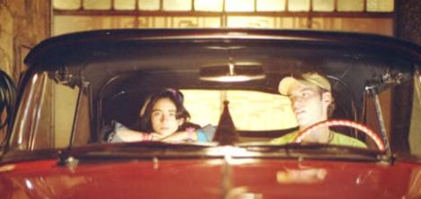 Dos jóvenes en un carro rojo 